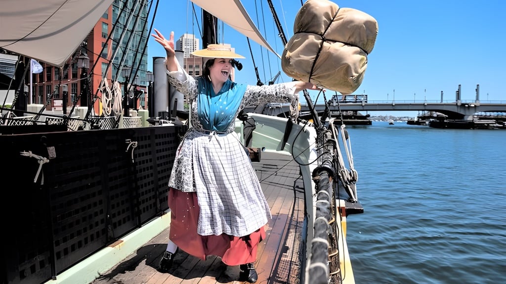 Replica tea ship at Boston Harbor with spectators during the reenactment