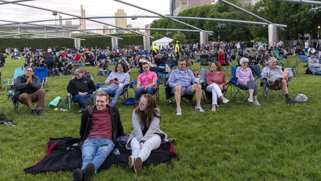 People dancing to music in a park area during the free festival