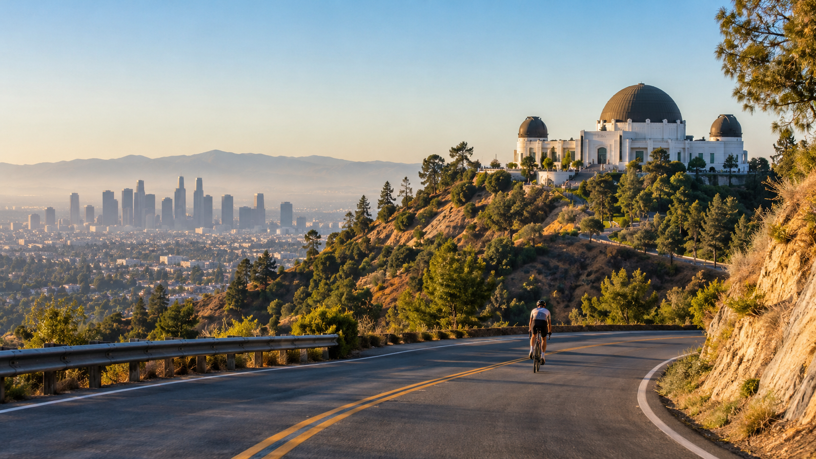 A lone cyclist approaches Griffith Observatory on a hill road